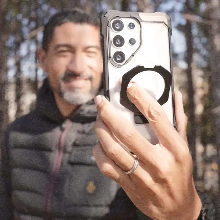 Smartphone in rugged case with finger grip.
